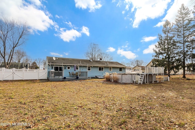 rear view of house featuring a yard and a swimming pool side deck