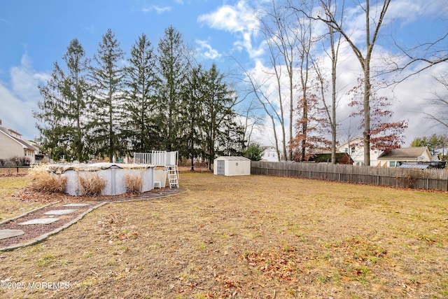 view of yard featuring a covered pool and a shed