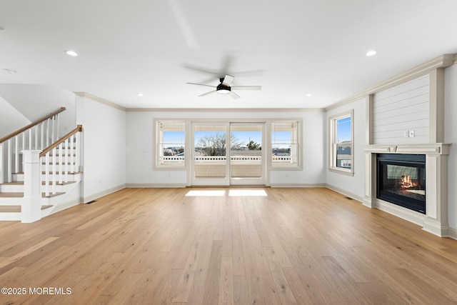 unfurnished living room featuring crown molding, ceiling fan, and light wood-type flooring