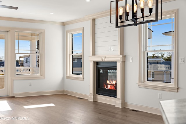 unfurnished living room featuring crown molding, dark wood-type flooring, and a chandelier