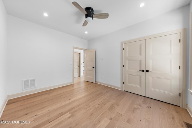 unfurnished bedroom featuring ceiling fan, light hardwood / wood-style floors, and a closet