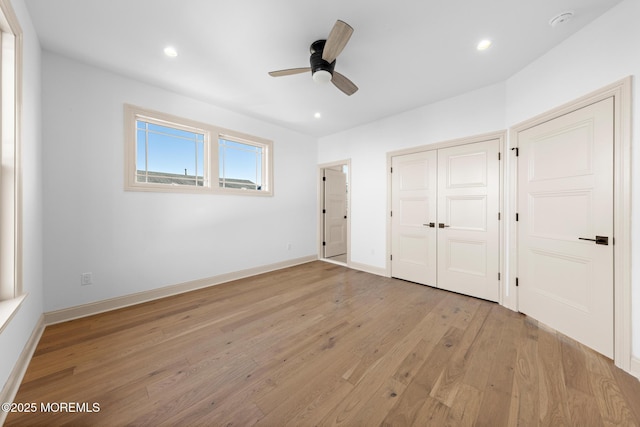 unfurnished bedroom featuring ceiling fan, a closet, and light wood-type flooring