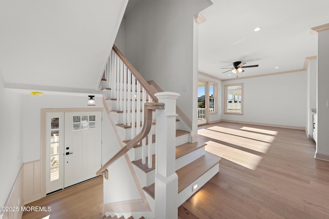 stairway featuring hardwood / wood-style flooring, crown molding, and ceiling fan