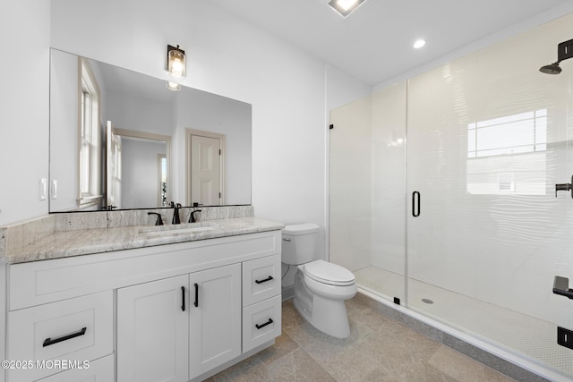 bathroom with vanity, a shower with shower door, and toilet