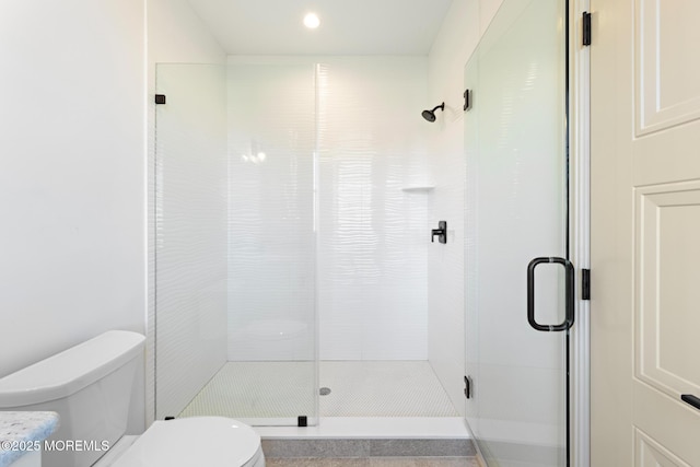 bathroom featuring an enclosed shower and toilet