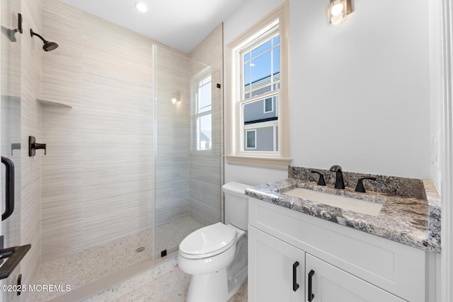 bathroom featuring vanity, an enclosed shower, and toilet