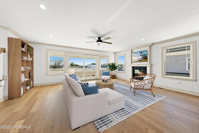 living room featuring ornamental molding, light hardwood / wood-style floors, and ceiling fan