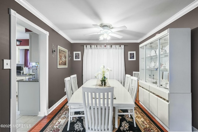 tiled dining room with ceiling fan and ornamental molding