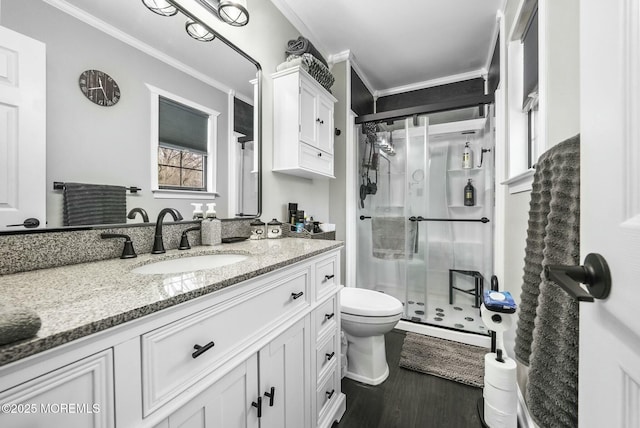 bathroom with hardwood / wood-style floors, ornamental molding, vanity, an enclosed shower, and toilet