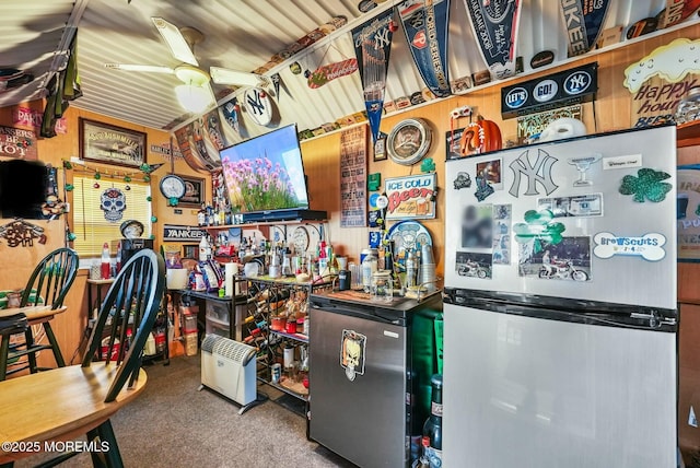 interior space featuring ceiling fan, stainless steel fridge, and carpet