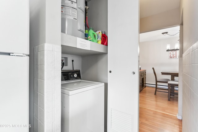 clothes washing area featuring washer / dryer and hardwood / wood-style flooring