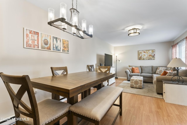 dining room featuring a baseboard radiator, a chandelier, and light wood-type flooring