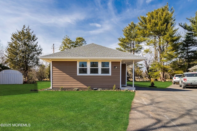 bungalow-style home featuring a front yard and a storage unit