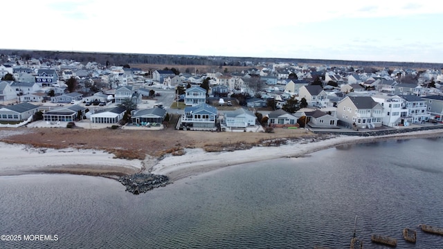 birds eye view of property featuring a water view and a beach view