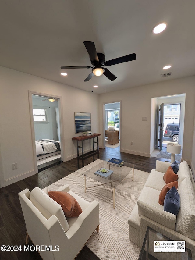 living room featuring ceiling fan and dark hardwood / wood-style flooring