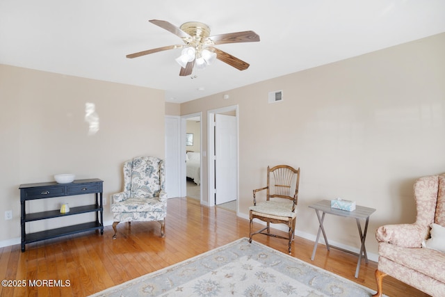 living area featuring ceiling fan and hardwood / wood-style floors