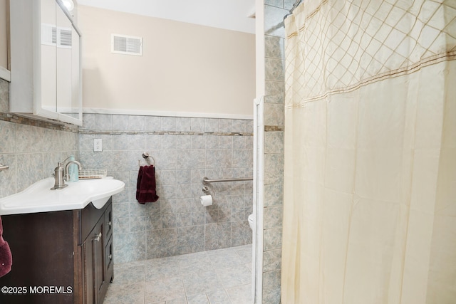 bathroom with tile patterned flooring, vanity, tile walls, and a shower with curtain