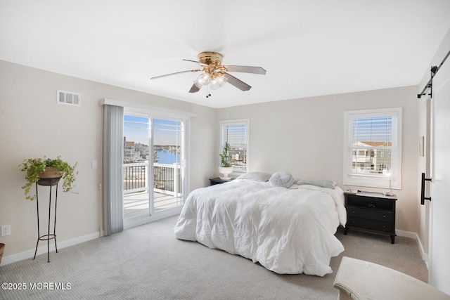 carpeted bedroom featuring ceiling fan, a barn door, multiple windows, and access to outside