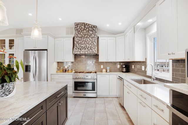 kitchen with sink, pendant lighting, stainless steel appliances, light stone countertops, and white cabinets