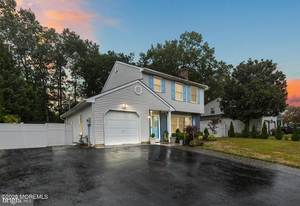 view of front of house with a garage and a lawn