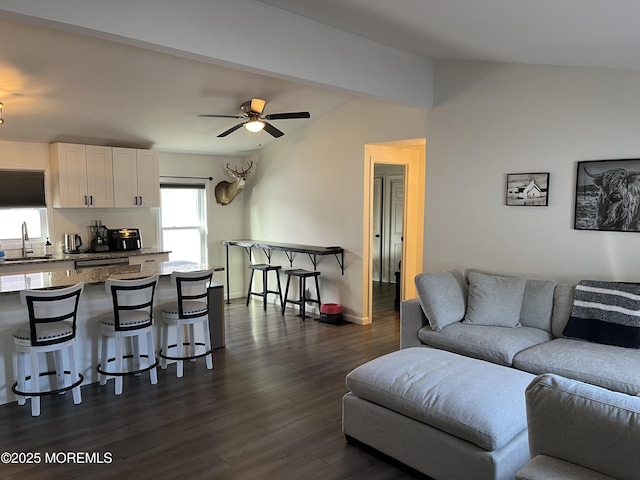 living room with ceiling fan, lofted ceiling, dark hardwood / wood-style floors, and sink