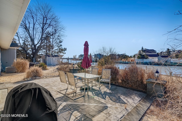 view of patio / terrace featuring cooling unit, a water view, and a grill