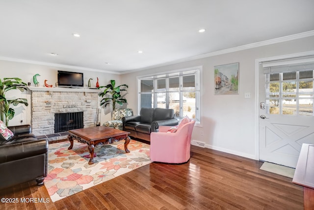 living room featuring hardwood / wood-style flooring, ornamental molding, and a fireplace