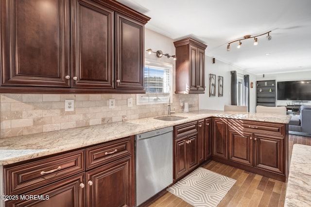 kitchen featuring tasteful backsplash, sink, stainless steel dishwasher, kitchen peninsula, and light stone countertops