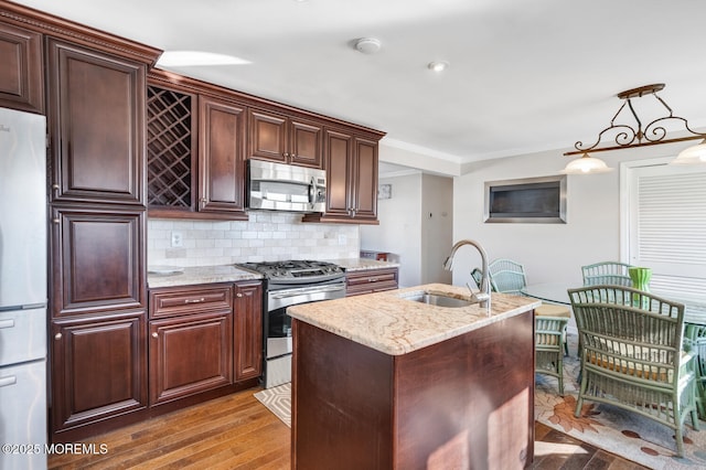 kitchen with crown molding, appliances with stainless steel finishes, light stone countertops, decorative backsplash, and decorative light fixtures