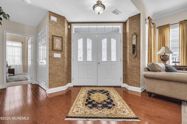 foyer entrance with crown molding and dark hardwood / wood-style flooring