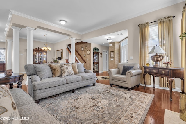 living room with ornamental molding, dark hardwood / wood-style floors, decorative columns, and a notable chandelier