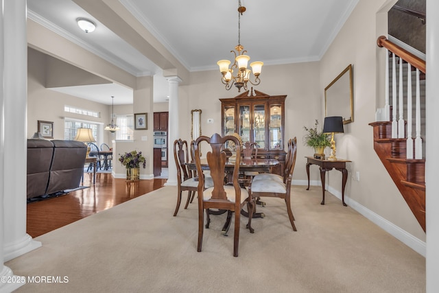 carpeted dining space featuring decorative columns, crown molding, and a notable chandelier