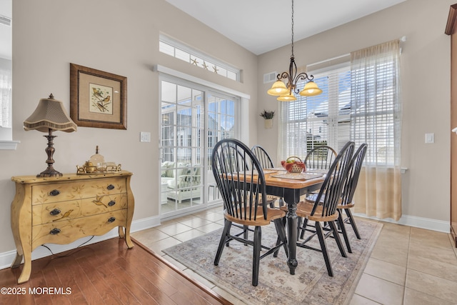 tiled dining room with plenty of natural light and a chandelier