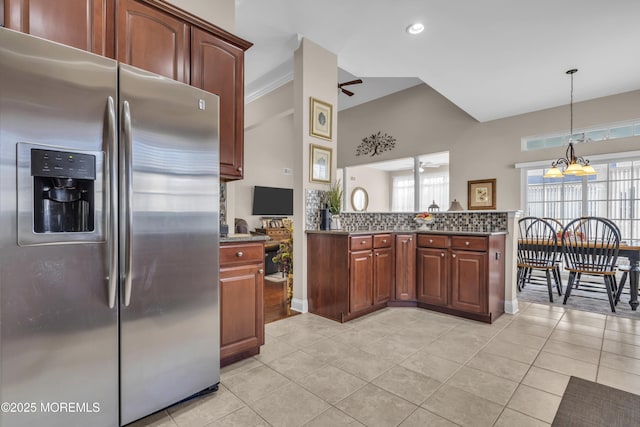 kitchen with stainless steel refrigerator with ice dispenser, plenty of natural light, ceiling fan with notable chandelier, and decorative light fixtures