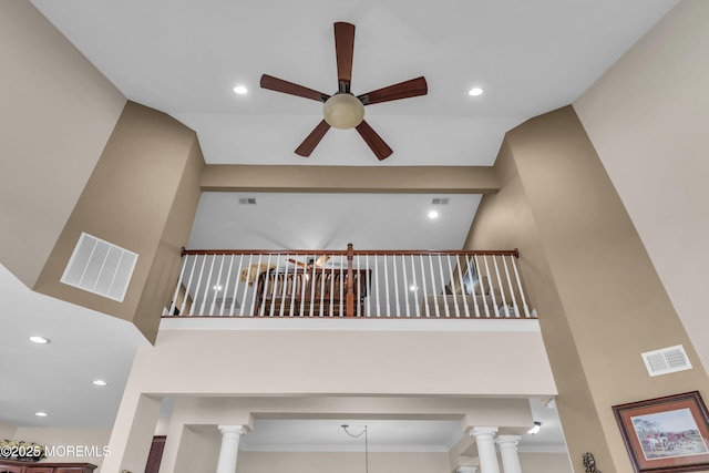 stairs featuring ceiling fan, a towering ceiling, and ornate columns