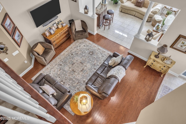 living room with decorative columns and light wood-type flooring