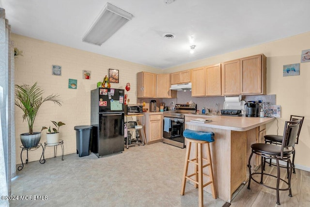 kitchen with stainless steel appliances, a kitchen breakfast bar, kitchen peninsula, and light brown cabinetry