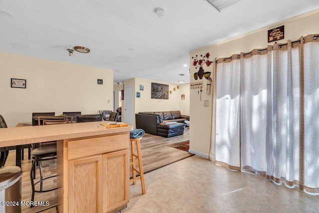 kitchen featuring a breakfast bar and light brown cabinets