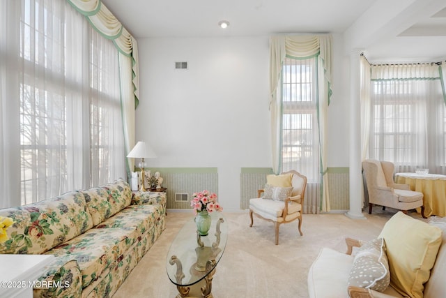 living room with ornate columns and light carpet