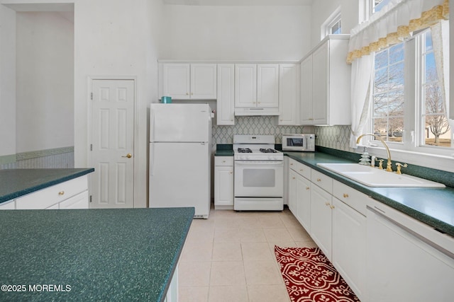 kitchen with white cabinetry, white appliances, and sink