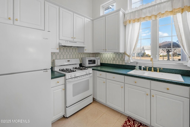 kitchen featuring sink, white appliances, tasteful backsplash, white cabinets, and light tile patterned flooring