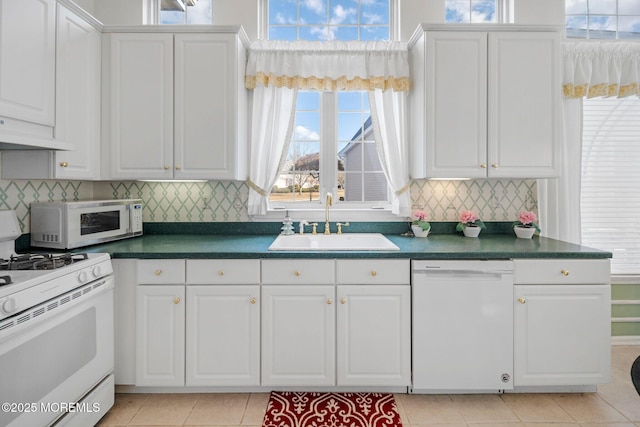 kitchen with light tile patterned flooring, sink, white cabinets, decorative backsplash, and white appliances