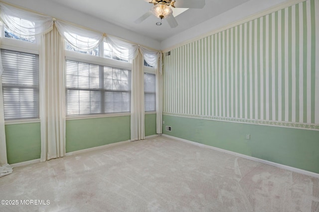 spare room with ceiling fan and light carpet