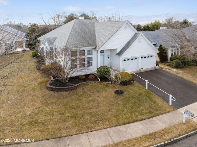 view of front of property with a garage and a front lawn