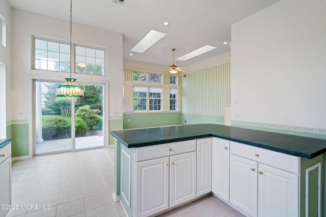 5 Shoal Dr, Barnegat, NJ 08005 - kitchen with a skylight, light tile patterned flooring, dark countertops, white cabinetry, and plenty of natural light
