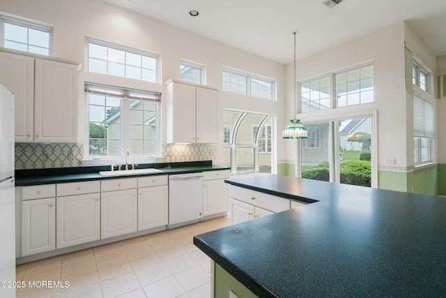 5 Shoal Dr, Barnegat, NJ 08005 - kitchen featuring white appliances, dark countertops, light tile patterned floors, white cabinets, and decorative backsplash