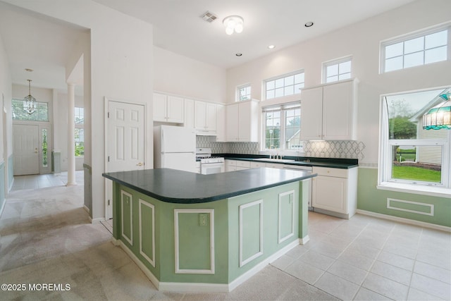 5 Shoal Dr, Barnegat, NJ 08005 - kitchen featuring white appliances, decorative columns, dark countertops, a towering ceiling, and a kitchen island