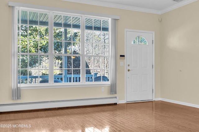 foyer entrance featuring hardwood / wood-style floors, ornamental molding, and baseboard heating