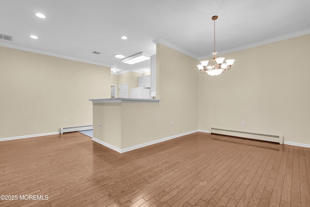 unfurnished room featuring crown molding, a baseboard heating unit, an inviting chandelier, and light wood-type flooring