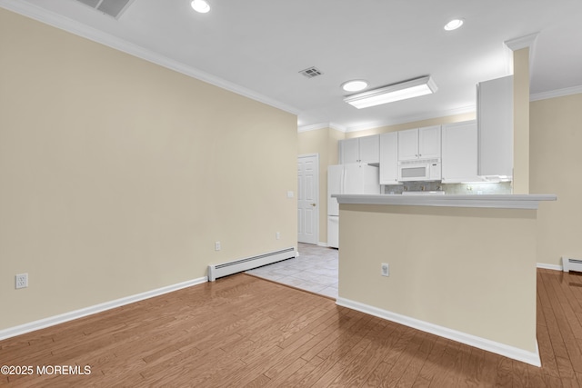 kitchen featuring white appliances, crown molding, baseboard heating, white cabinetry, and kitchen peninsula